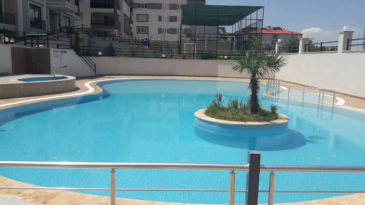 Safir mavisi suyu ve huzur veren atmosferiyle göz alıcı bir yüzme havuzu.